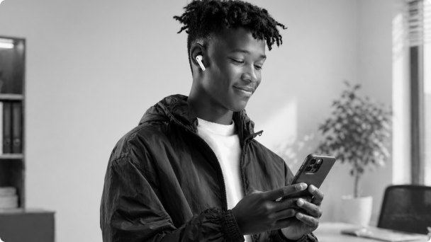 Pessoa sorrindo enquanto usa o celular